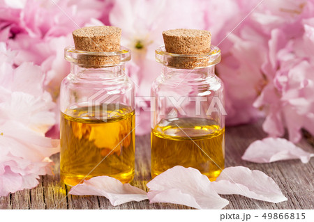Two bottles of essential oil with pink blossoms 49866815