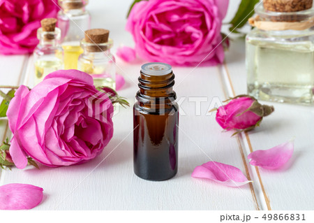 A bottle of essential oil with fresh roses A bottle of essential oil with fresh roses 49866831
