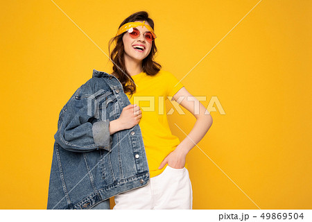 Cheerful hipster girl posing isolated on yellow 49869504