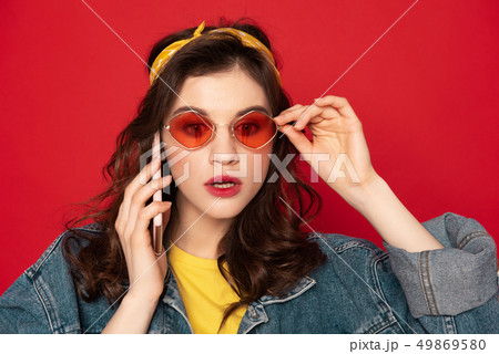 Shocked hipster girl talking by mobile phone Shocked hipster girl talking by mobile phone 49869580