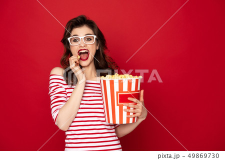 Happy excited pretty brunette lady eating pop corn Happy excited pretty brunette lady eating pop corn 49869730