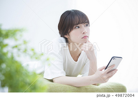 スマートフォンを見る若い女性 スマートフォンを見る若い女性 49872004