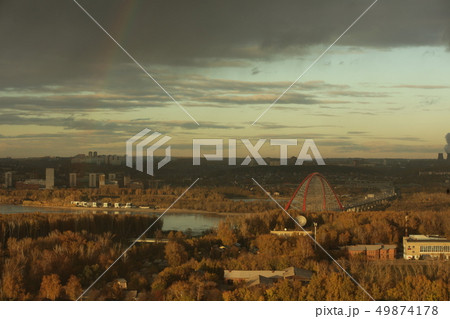 Bugrinsky bridge over the Ob river in Novosibirsk against cloudy sky with a bright rainbow Bugrinsky bridge over the Ob river in Novosibirsk against cloudy sky with a bright rainbow 49874178