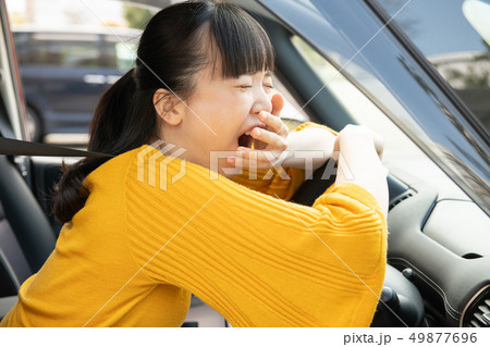 運転に疲れて欠伸をする若い日本人女性　ドライブ 49877696