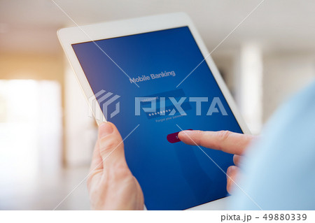 A man using online banking on a tablet 49880339