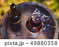 Glass of red wine with bottle 49880358
