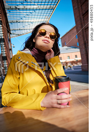 young woman in yellow raincoat at city street 49880455
