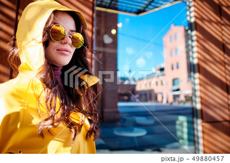 young woman in yellow raincoat at city street 49880457