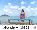 Woman sitting on a chair on the bridge in the sea 49882448