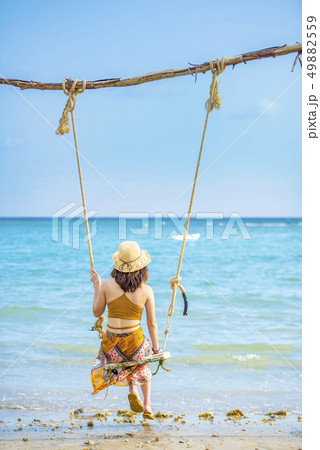 Women sitting on the beach swing, Koh Mak 49882559