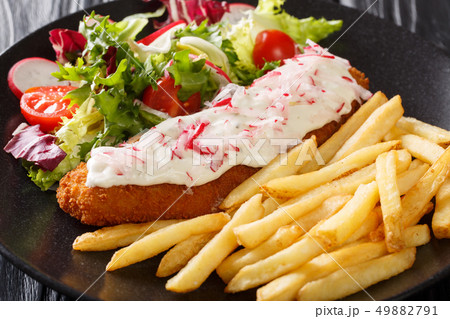 fish in breading with a side dish of french fries 49882791