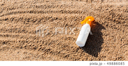 Suntan lotion white bottle on sand with copy 49886085