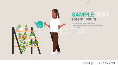 housewife watering potted plants on rack african american woman holding sprinkling can girl doing 49887749