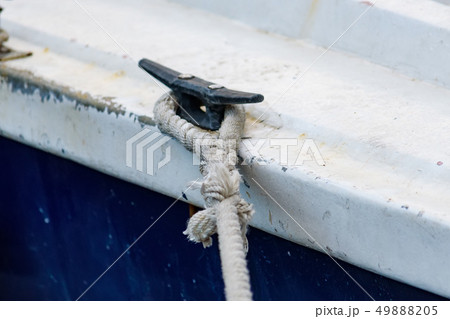 Close up of boat rope tied to nautical cleat hitch on boat 49888205