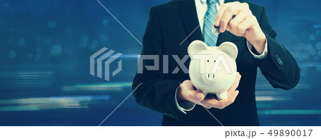 Businessman with a piggy bank Businessman with a piggy bank 49890017
