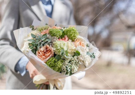 beautiful fresh cut bouquet of mixed flowers in woman hand. the work of the florist at a flower shop beautiful fresh cut bouquet of mixed flowers in woman hand. the work of the florist at a flower shop 49892251