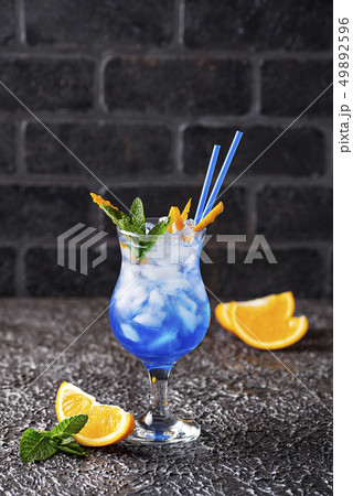 Blue cocktail drink with ice and orange 49892596