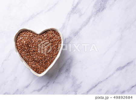 Flax seeds in heart shape bowl 49892684