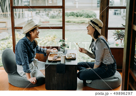 girlfriends laughing with jokes drinking matcha 49896297