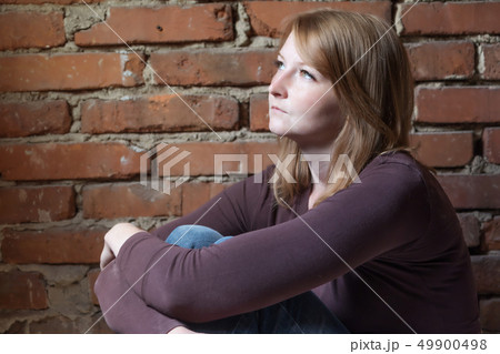 Side view of a saddly young woman Side view of a saddly young woman 49900498