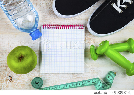 Gym shoes, dumbbells, a bottle of water, an apple Gym shoes, dumbbells, a bottle of water, an apple 49909816