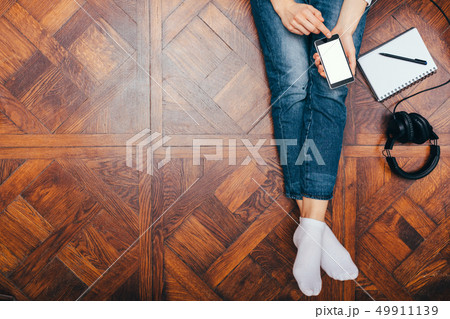 Top view young woman sitting on wooden floor 49911139