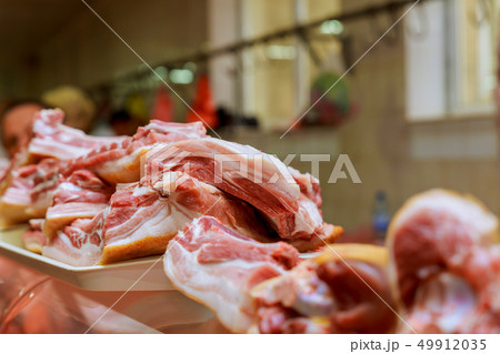 Butcher cuts a piece of meat in the market Butcher cuts a piece of meat in the market 49912035