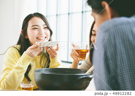 食事をする若い男性と女性　鍋パーティーイメージ　宅飲み　 49912282