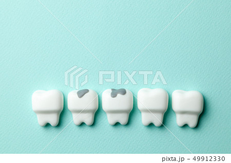 Healthy white teeth and tooth with caries on green mint background. Copy space for text. 49912330
