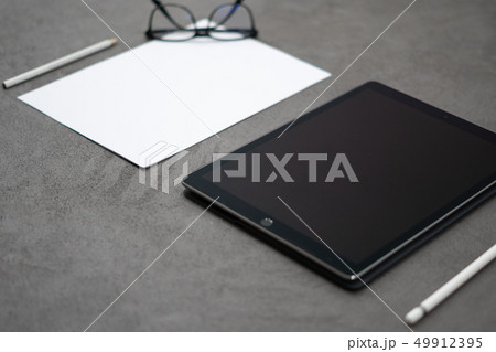tablet with pen on a concrete table tablet with pen on a concrete table 49912395