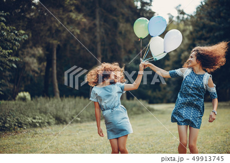 Two cute sisters in a summer park 49913745