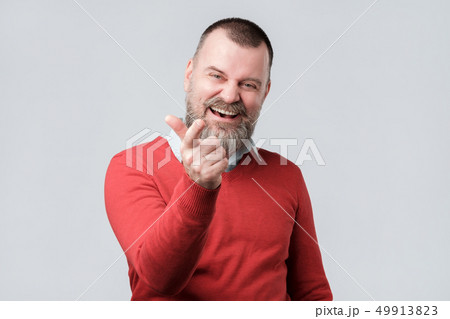 man in red sweater pointing his finger at you 49913823