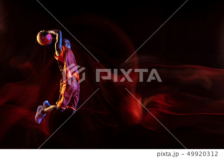 Young basketball player against dark background Young basketball player against dark background 49920312