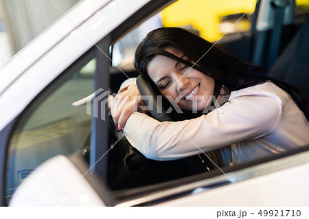 Happy customer woman buying a new car in dealeship center 49921710