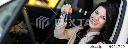 Happy customer woman buying a new car in dealeship center Happy customer woman buying a new car in dealeship center 49921749