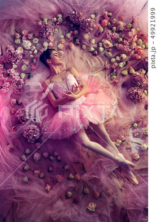 Young woman in pink ballet tutu surrounded by flowers 49921999
