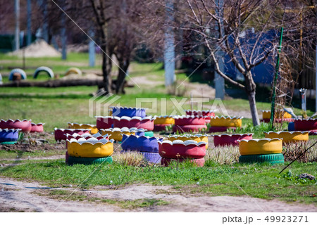 Colorful flowerbeds made of several old car tires 49923271