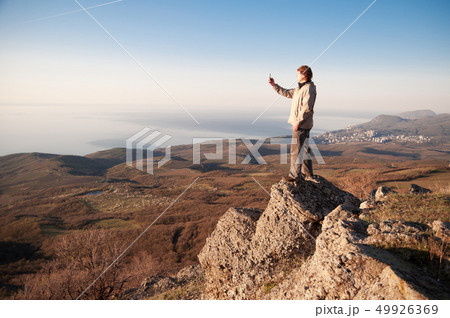Man with mobile phone on the top of world Man with mobile phone on the top of world 49926369