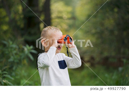 The little boy and orange binoculars 49927790