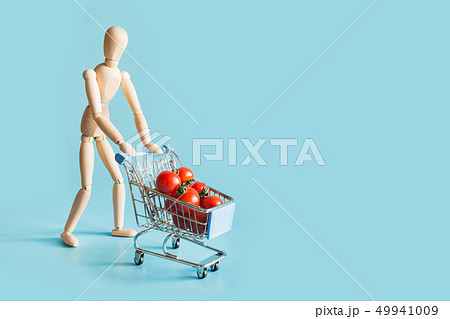 Buyer as wooden dolls with grocery trolley, tomato Buyer as wooden dolls with grocery trolley, tomato 49941009