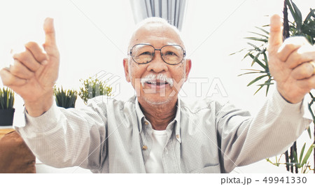Asian senior making a thumb up gesture and smiling 49941330