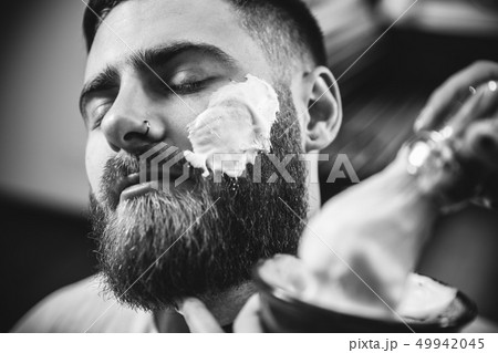 Client during beard shaving in barber shop 49942045