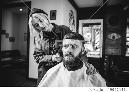 Client during beard shaving in barber shop 49942131
