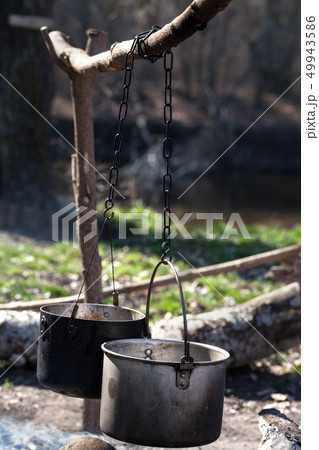 Two sooty old cauldrons on bonfire at forest Two sooty old cauldrons on bonfire at forest 49943586