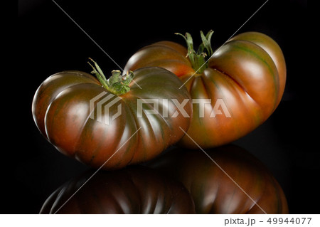 Fresh dark tomato primora isolated on black glass 49944077