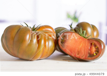 Fresh dark tomato primora with red tulips Fresh dark tomato primora with red tulips 49944079