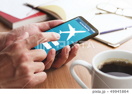 スマートフォンで航空券の予約をする男性の手のアップ。 スマートフォンで航空券の予約をする男性の手のアップ。 49945864