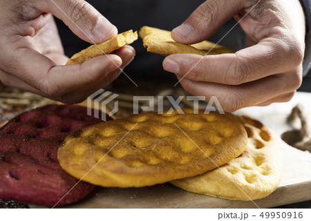 man splitting a piece of an italian focaccia. 49950916