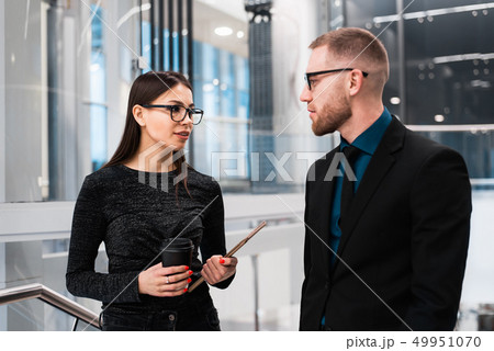 Businessman and businesswoman discussing something during the coffee break Businessman and businesswoman discussing something during the coffee break 49951070