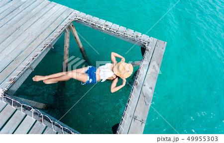 woman sleeps on a hammock at the pier near woman sleeps on a hammock at the pier near 49955303
